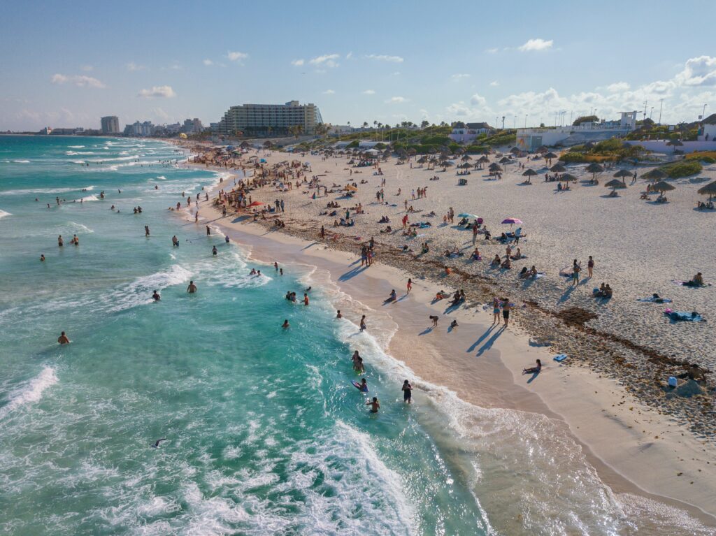 people standing and swimming on ocean at daytime